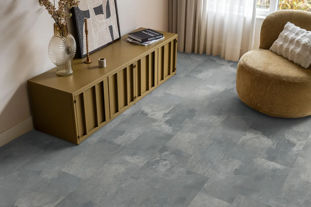 Madison Square Aqua / Expression Aqua middengrijs, tegellaminaat met natuursteenlook in een woonkamer met een okergeel dressoir en een ronde fauteuil
