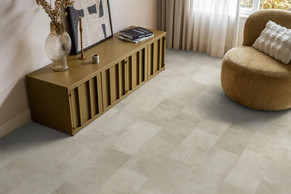 Madison Square Aqua / Expression Aqua grijsbruin, tegellaminaat met natuursteenlook in een woonkamer met een okergeel dressoir en een ronde fauteuil