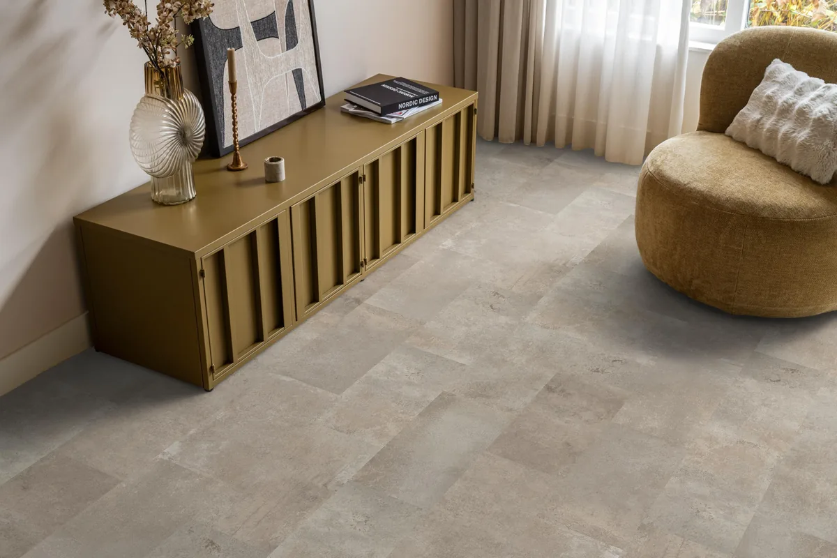Madison Square Aqua / Expression Aqua zand, tegellaminaat met natuursteenlook in een woonkamer met een okergeel dressoir en een ronde fauteuil