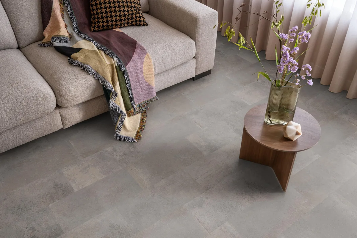 Madison Square Aqua / Expression Aqua grijs, tegellaminaat met natuursteenlook in een woonkamer met een lichte bank en een houten bijzettafel