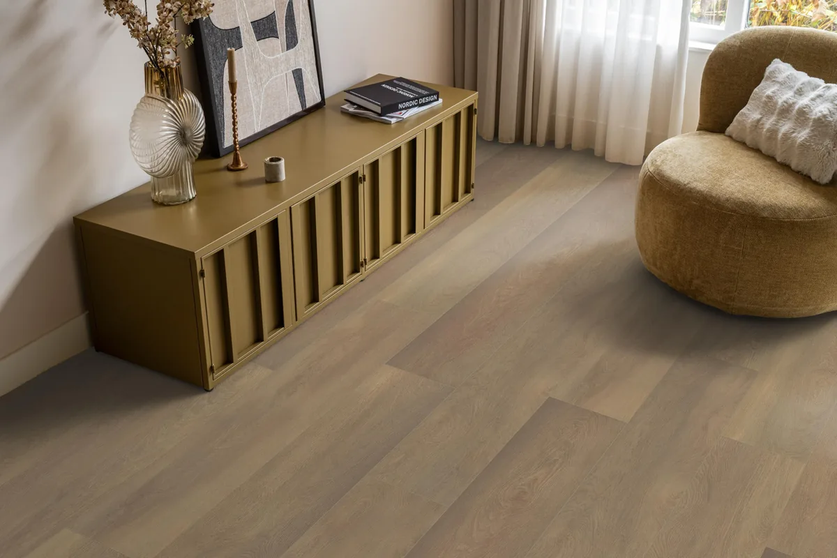 East Village / Arnstadt smoky eiken, laminaat in een woonkamer met een okergeel dressoir en een ronde fauteuil