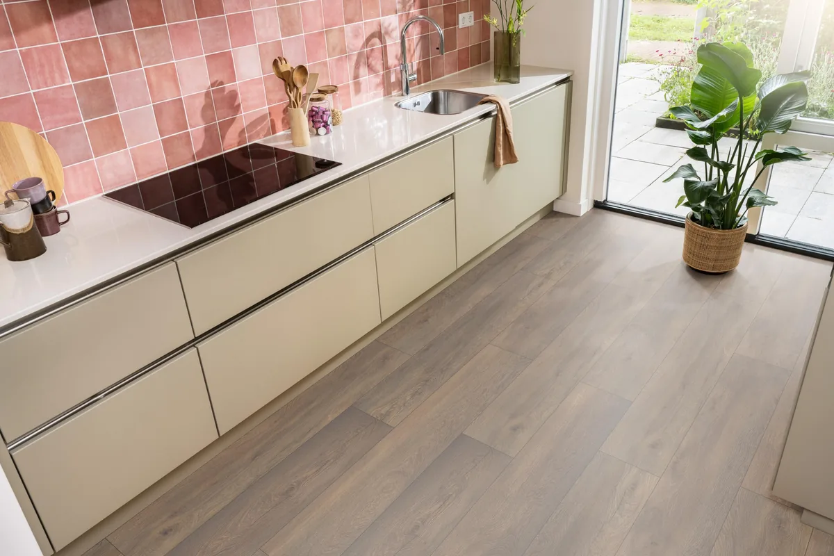 Union Square / Saarland donkerbruin eiken, laminaat in een keuken met roze tegelwand en openslaande tuindeuren