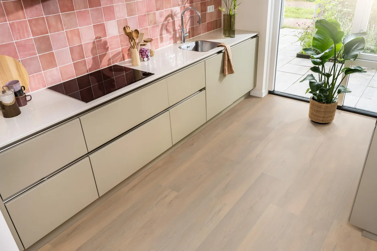 Union Square / Saarland natuur eiken, laminaat in een keuken met roze tegelwand en openslaande tuindeuren