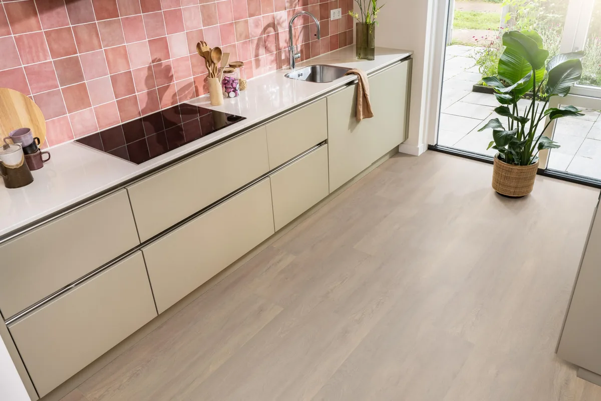 Union Square / Saarland smoky eiken, laminaat in een keuken met roze tegelwand en openslaande tuindeuren