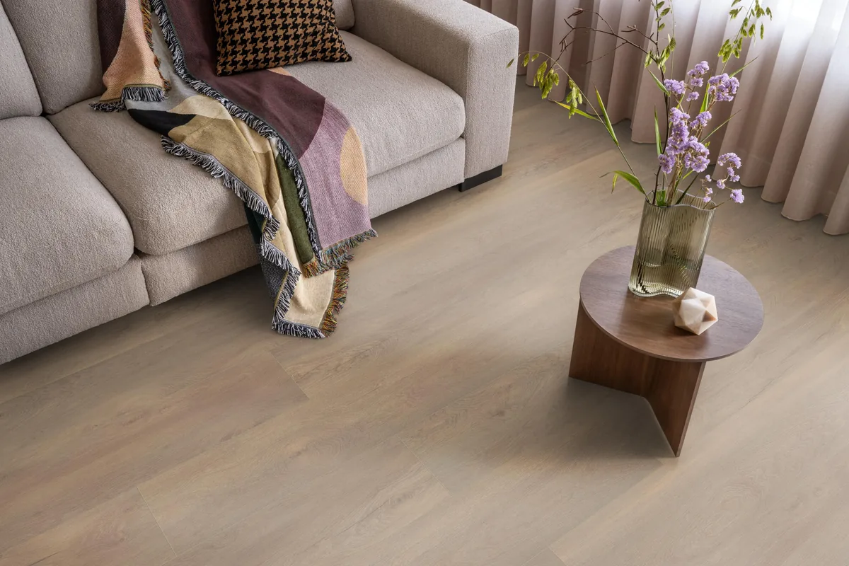 Union Square / Saarland smoky eiken, laminaat in een woonkamer met een lichte bank en een houten bijzettafel