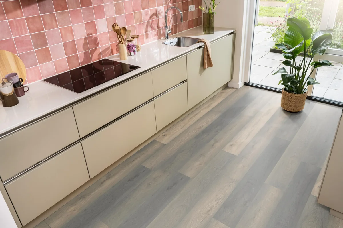 Midwood / Saksen titan eiken, laminaat in een keuken met roze tegelwand en openslaande tuindeuren