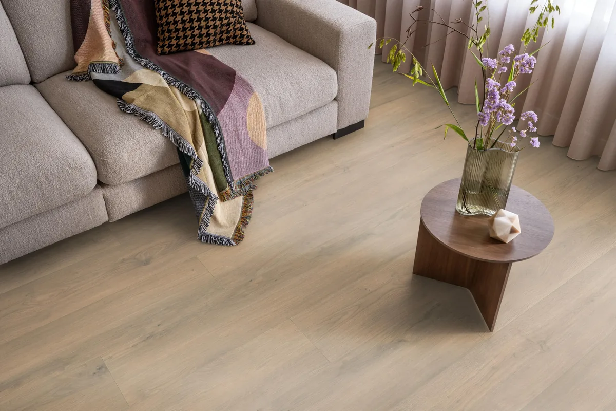 Marble Hill / Sereno beige eiken, laminaat in een woonkamer met een lichte bank en een houten bijzettafel