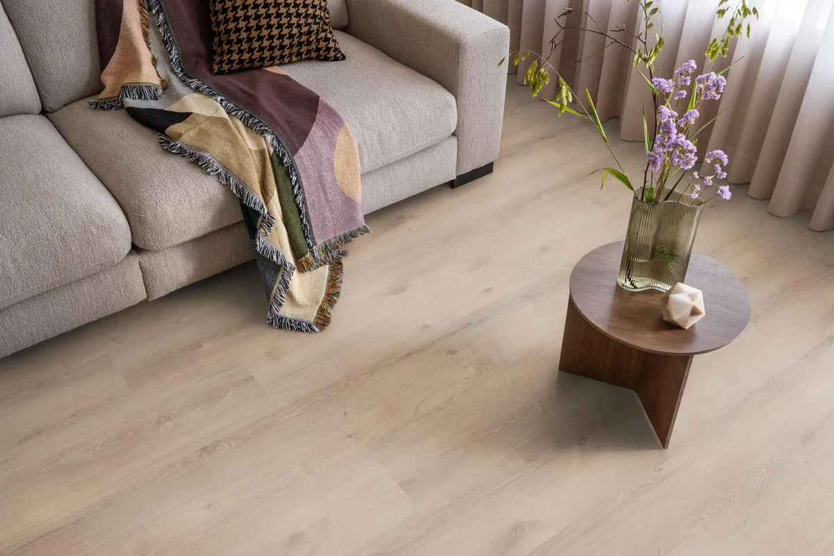 Inwood WR / Ingelstad blond eiken, laminaat in een woonkamer met een lichte bank en een houten bijzettafel