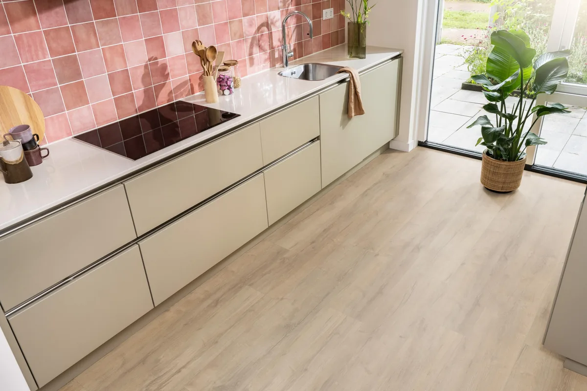 Sunnyside / Superior oak licht eiken, laminaat in een keuken met roze tegelwand en openslaande tuindeuren