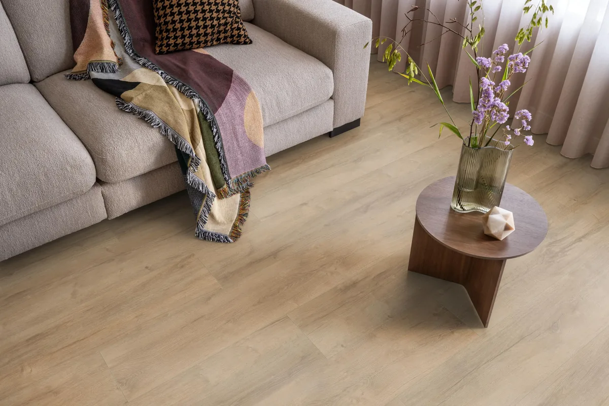 Sunnyside / Superior oak licht eiken, laminaat in een woonkamer met een lichte bank en een houten bijzettafel