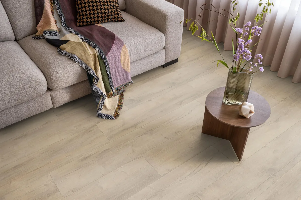 Sunnyside / Superior oak beige eiken, laminaat in een woonkamer met een lichte bank en een houten bijzettafel