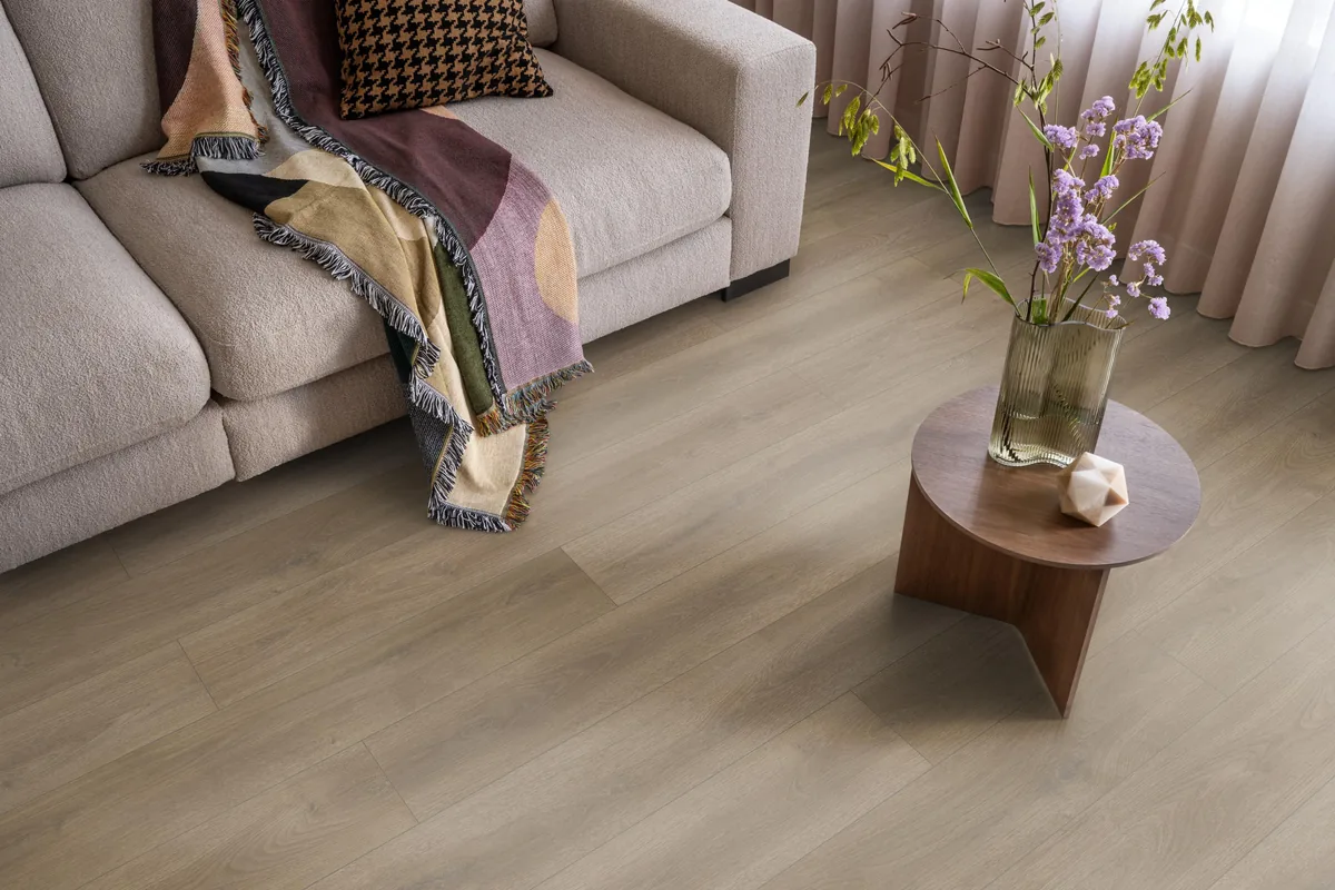 Woodside / Sunny oak smoky eiken, laminaat in een woonkamer met een lichte bank en een houten bijzettafel