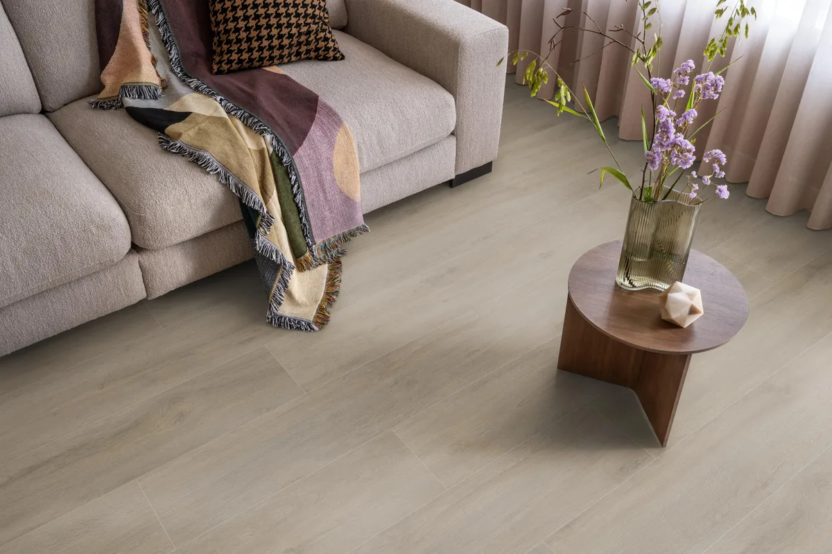 Norwood / Prestige oak grijsbruin eiken, laminaat in een woonkamer met een lichte bank en een houten bijzettafel