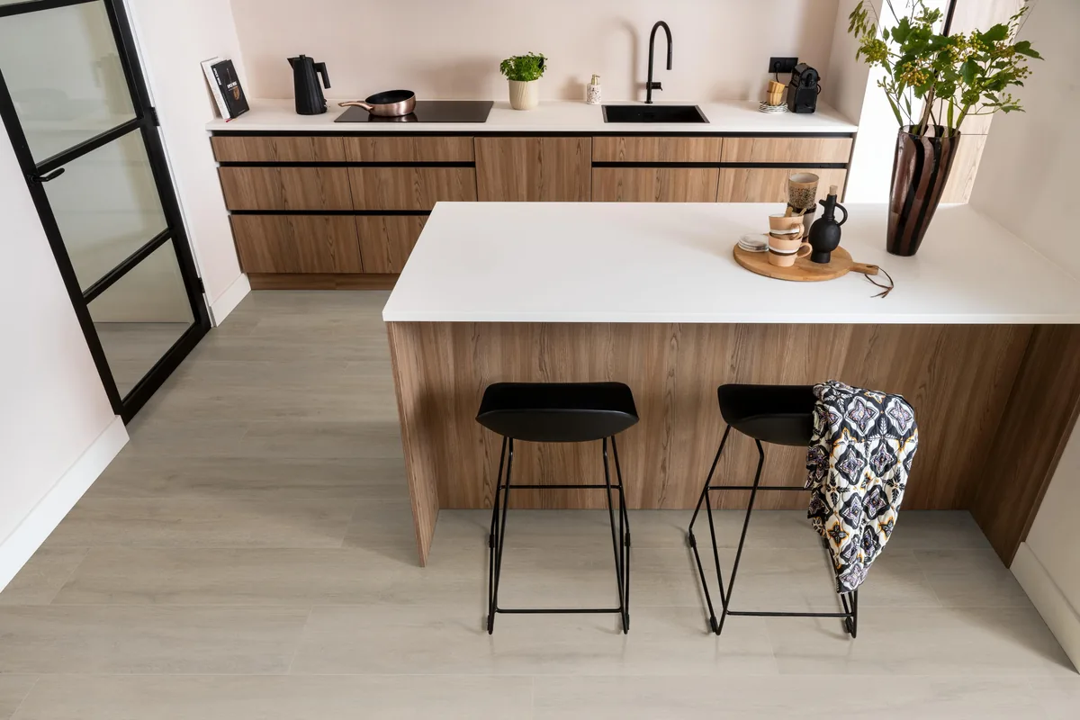 Norwood / Prestige oak grijsbruin eiken, laminaat in een keuken met een houten kookeiland en zwarte barkrukken