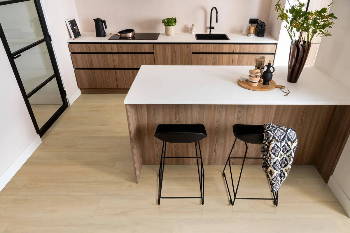 Norwood / Prestige oak natuur eiken, laminaat in een keuken met een houten kookeiland en zwarte barkrukken