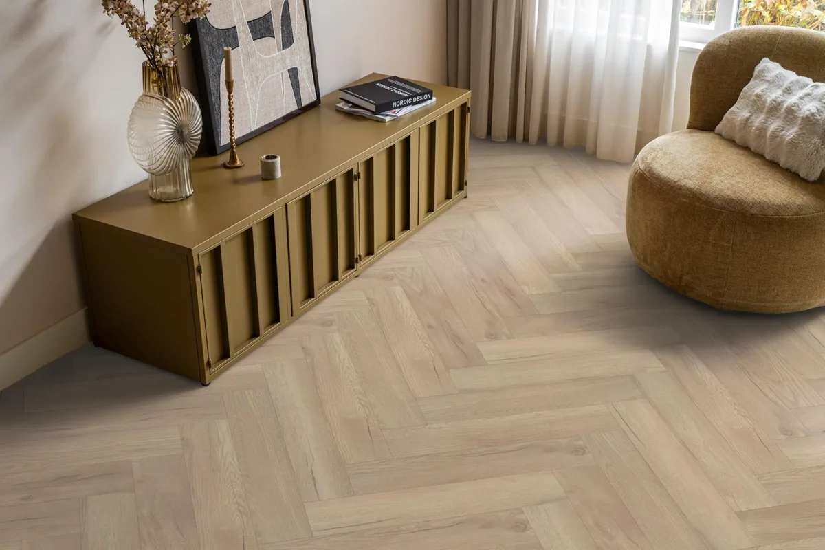Bayside / Marquant eiken licht naturel, visgraat laminaat in een woonkamer met een okergeel dressoir en een ronde fauteuil