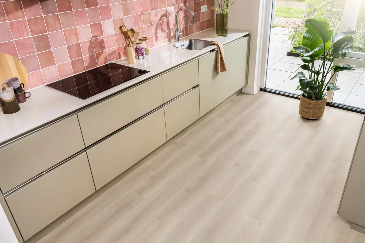 Queens / Elite naturel eiken, laminaat in een keuken met roze tegelwand en openslaande tuindeuren