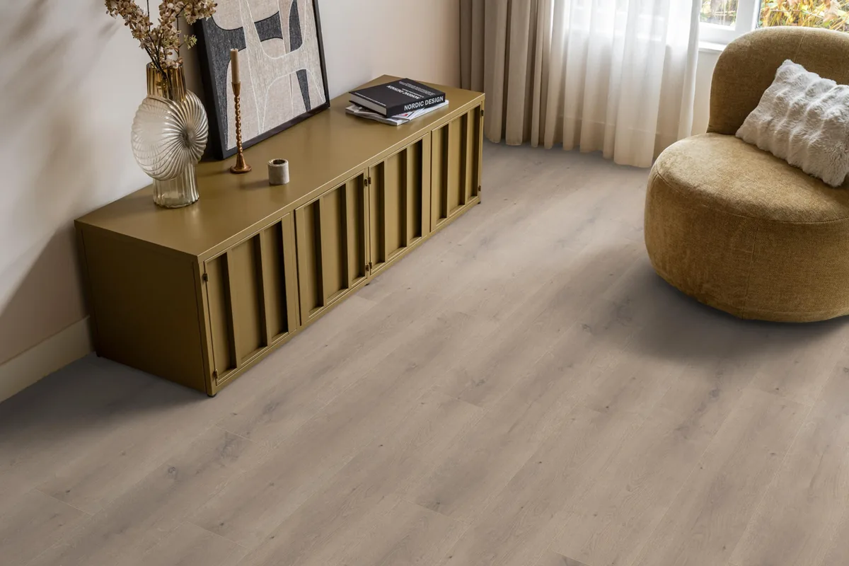 Queens / Elite beige eiken, laminaat in een woonkamer met een okergeel dressoir en een ronde fauteuil