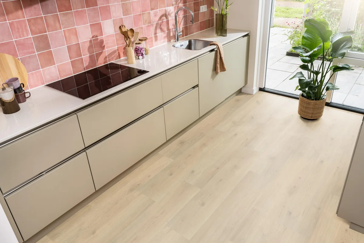 Forest Hills / Aachen beige eiken, laminaat in een keuken met roze tegelwand en openslaande tuindeuren