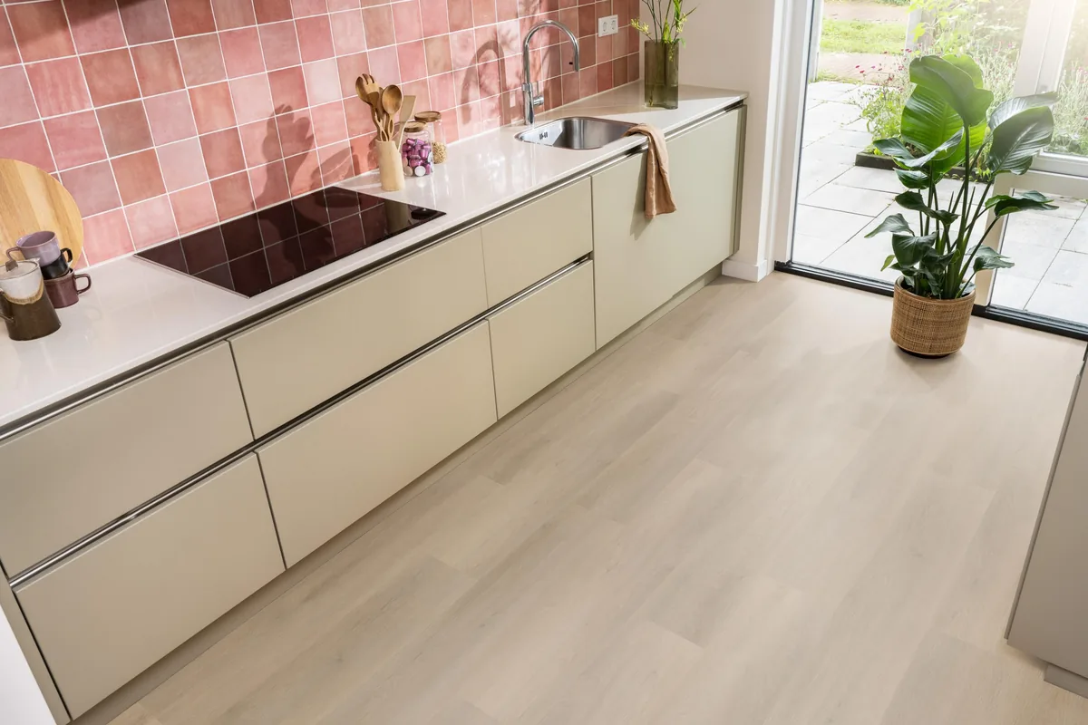 Newham / Sentima Beige, klik pvc in een keuken met een roze tegelwand en openslaande tuindeuren