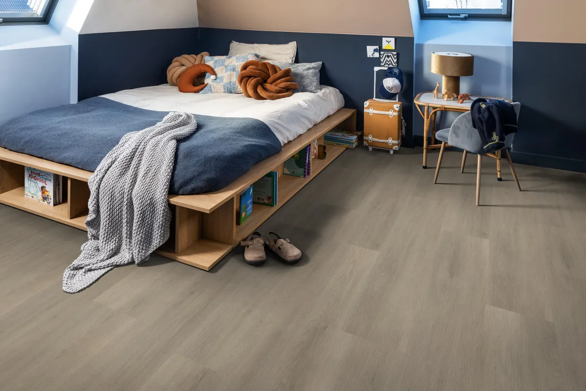 Newham / Sentima Smoky, klik pvc in een slaapkamer onder een schuin dak, met een houten bedombouw en sloffen ervoor