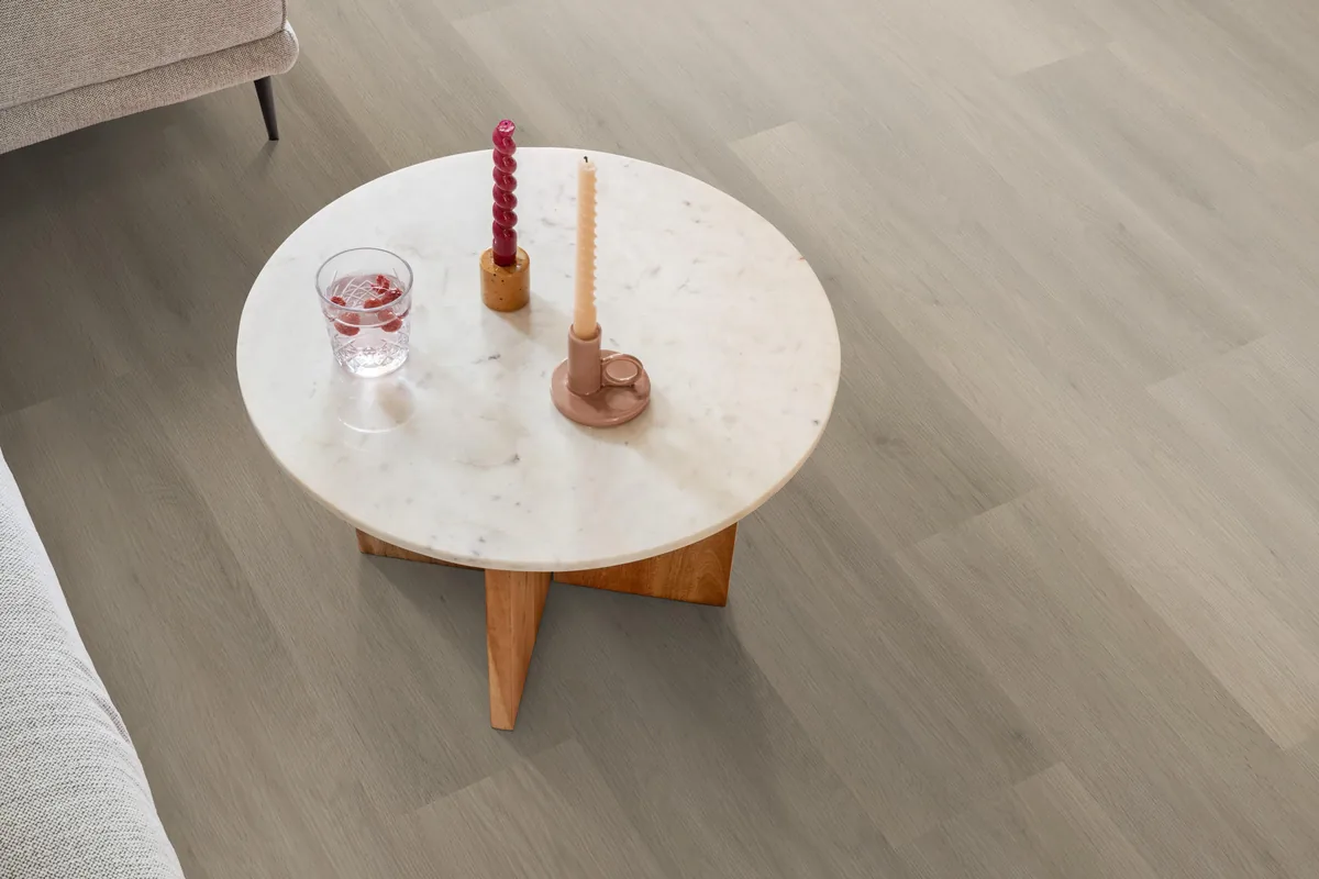 Newham / Sentima Smoky, klik pvc in een woonkamer, met een ronde marmeren salontafel en twee kaarsen