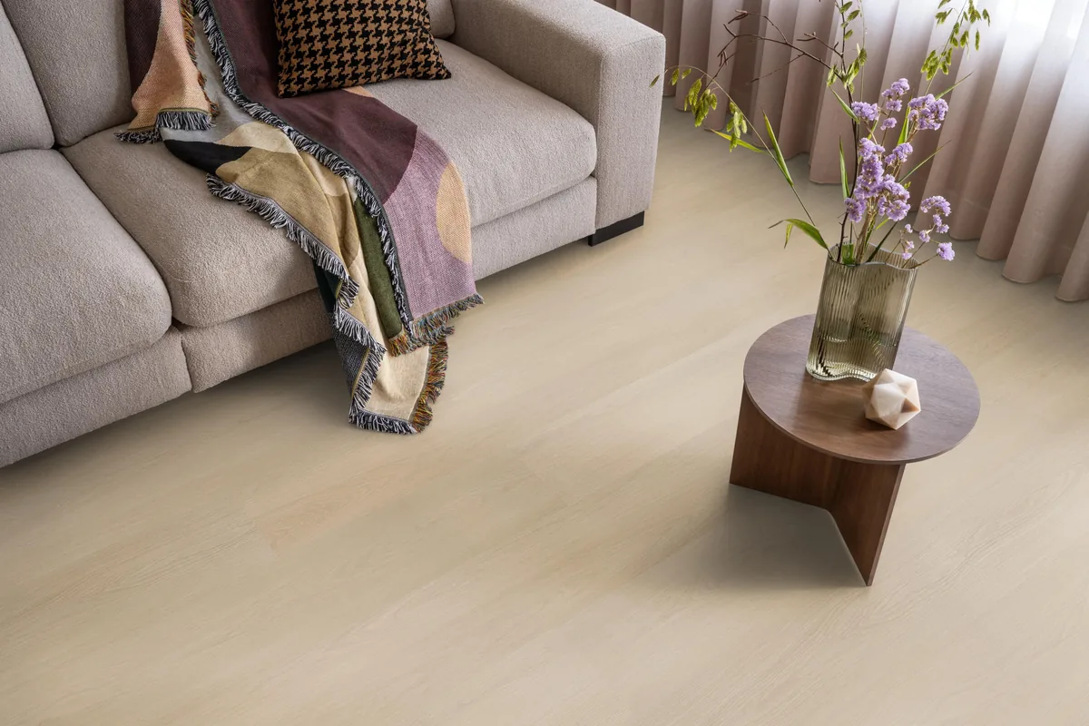 Brentford / Soleno Natural, plak pvc in een woonkamer, met een beige bank en een ronde bijzettafel met bloemen