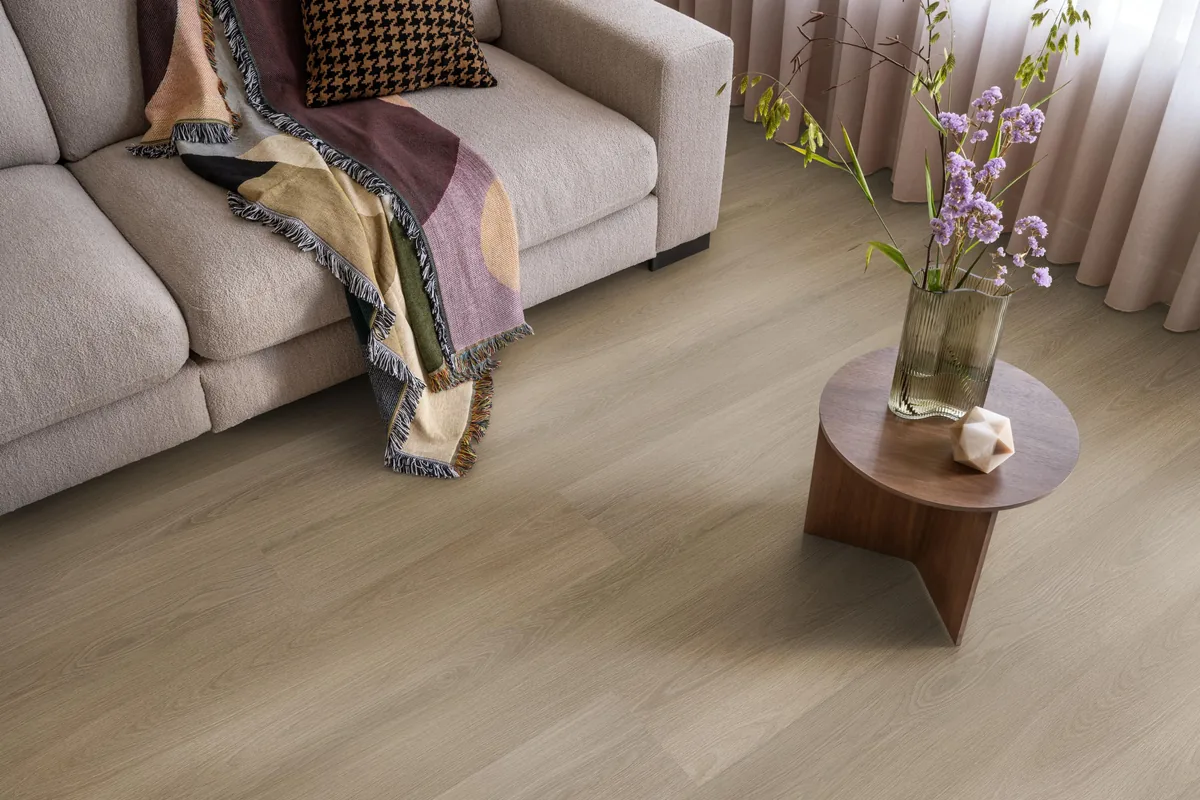 Brentford / Soleno Dark oak, plak pvc in een woonkamer, met een beige bank en een ronde bijzettafel met bloemen