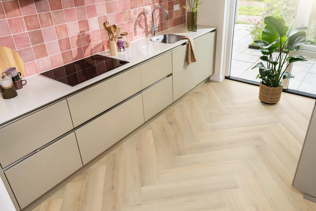 Greenford / Valento Natural, visgraat plak pvc in een keuken met een roze tegelwand en openslaande tuindeuren