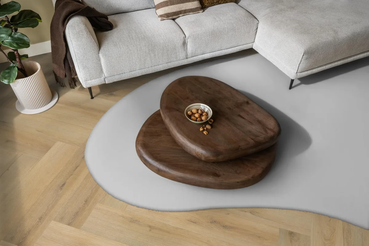 Greenford / Valento Natural, visgraat plak pvc in een woonkamer, met een lichte hoekbank en een wit vloerkleed