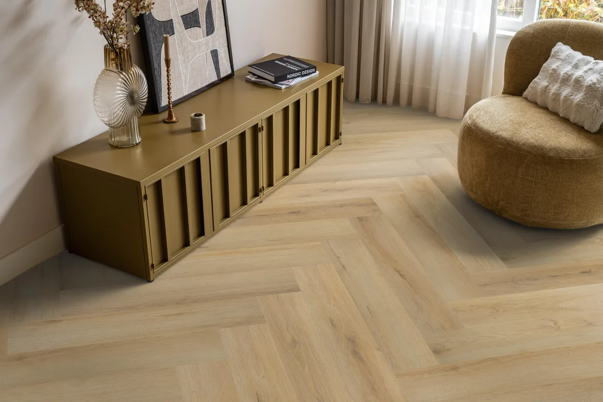 Greenford / Valento Natural, visgraat plak pvc in een woonkamer, met een okergeel dressoir en een ronde fauteuil
