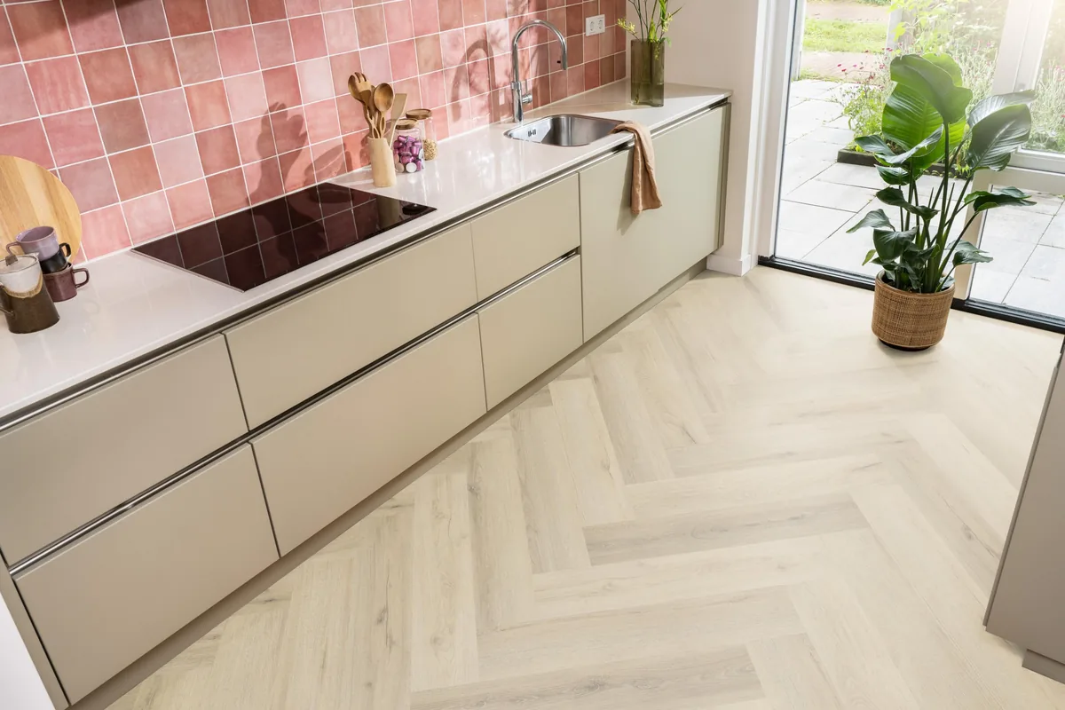 Greenford / Valento Warm beige, visgraat plak pvc in een keuken met een roze tegelwand en openslaande tuindeuren