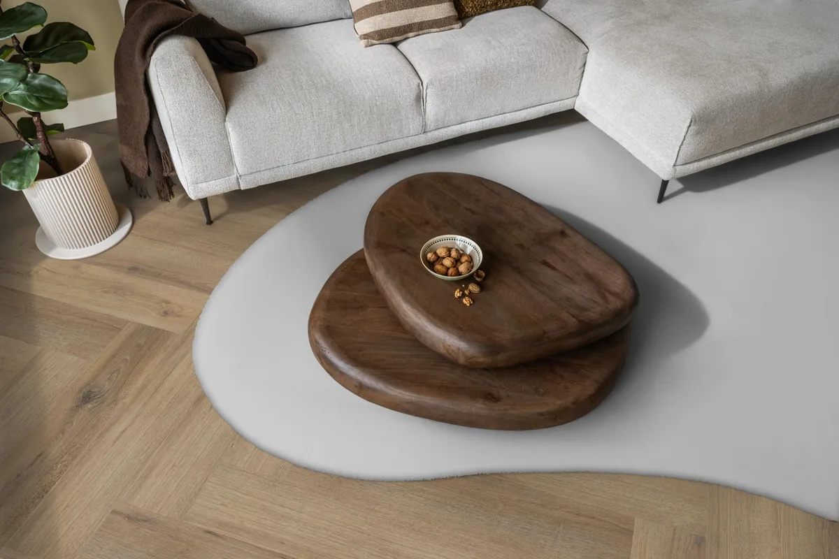 Greenford / Valento Light brown, visgraat plak pvc in een woonkamer, met een lichte hoekbank en een wit vloerkleed