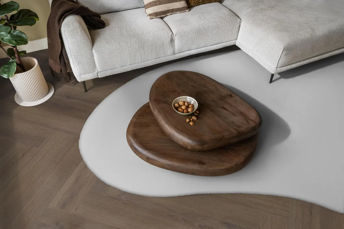 Greenford / Valento Brown, visgraat plak pvc in een woonkamer, met een lichte hoekbank en een wit vloerkleed