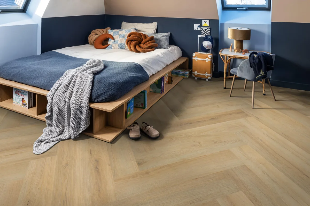 Greenford / Valento Natural, visgraat klik pvc in een slaapkamer onder een schuin dak, met een houten bedombouw en sloffen ervoor