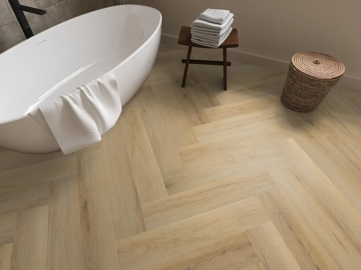 Greenford / Valento Natural, visgraat klik pvc in een badkamer, met een vrijstaand bad en een rieten wasmand