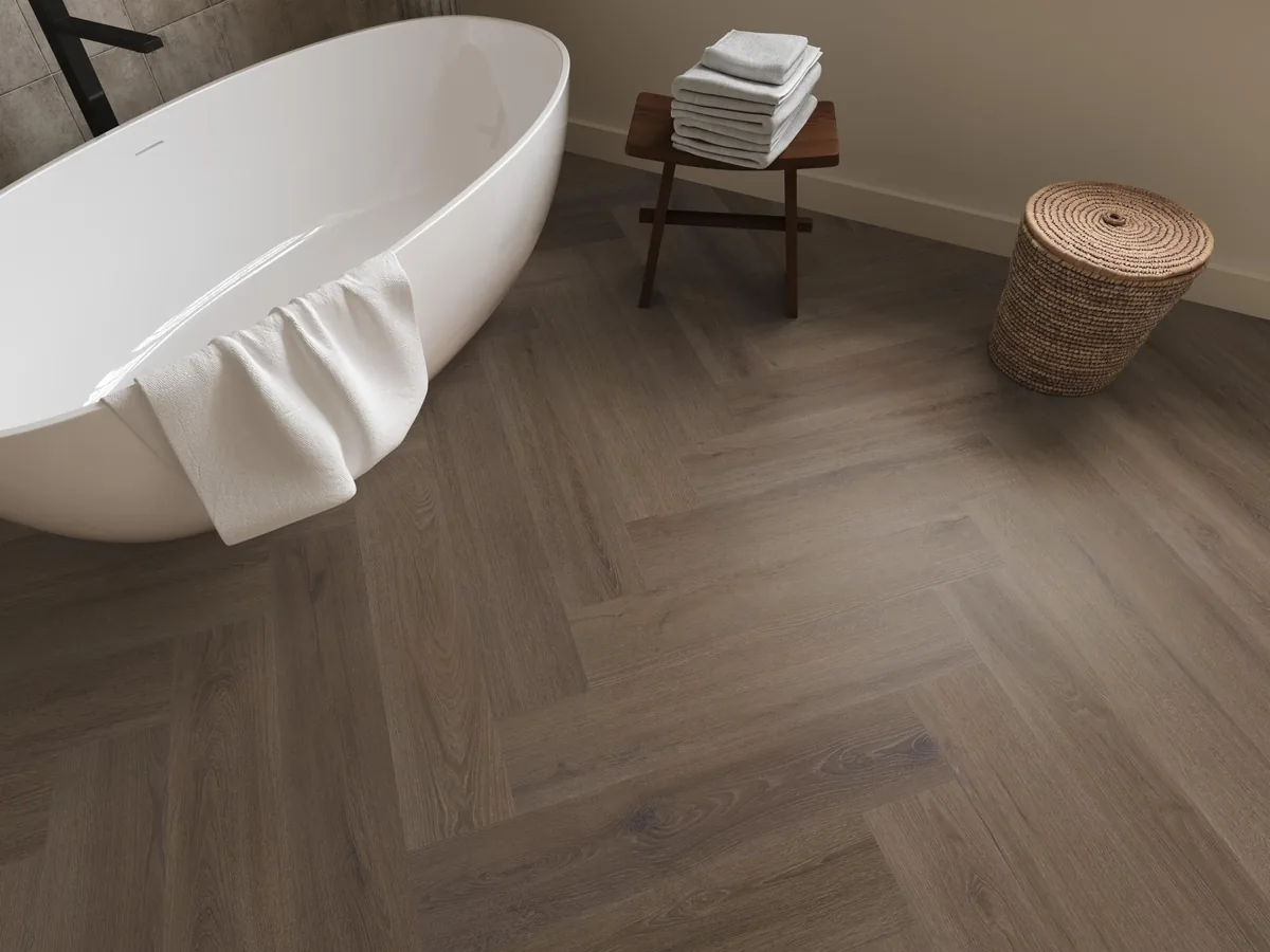 Greenford / Valento Brown, visgraat klik pvc in een badkamer, met een vrijstaand bad en een rieten wasmand