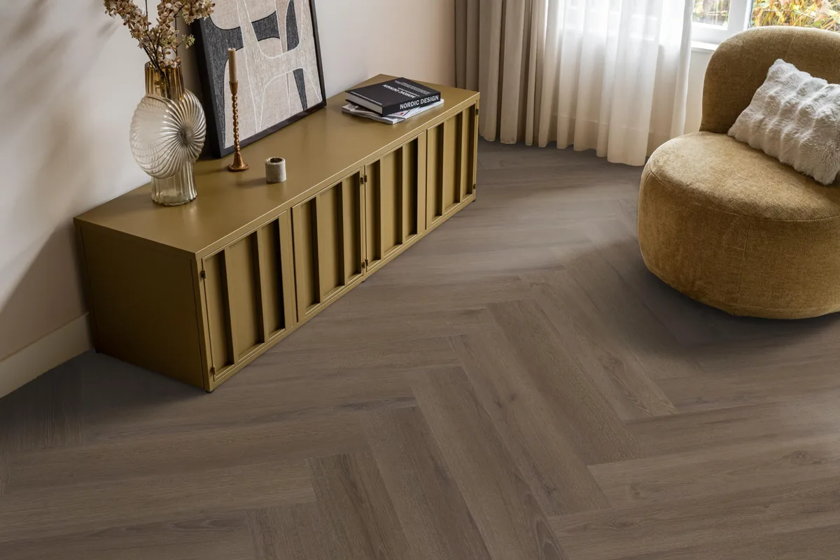 Greenford / Valento Brown, visgraat klik pvc in een woonkamer, met een okergeel dressoir en een ronde fauteuil
