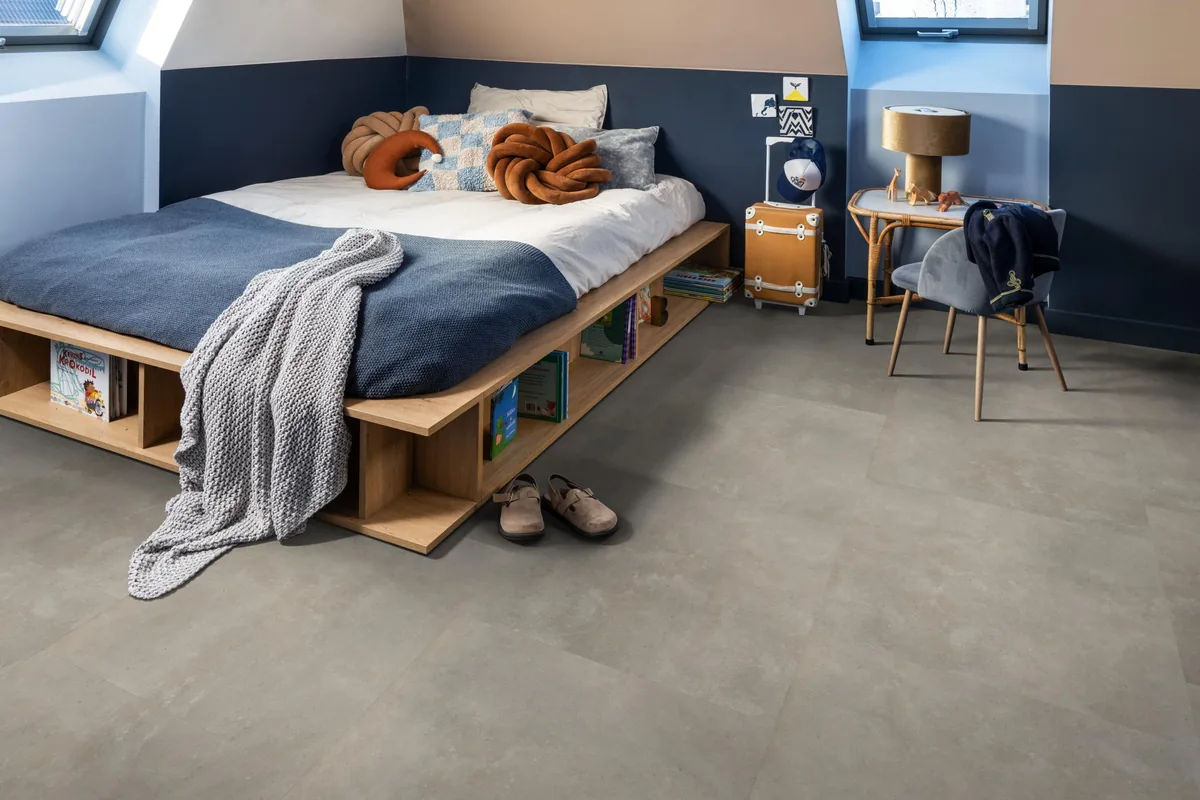 Victoria / Ceramo beige, plak pvc in een slaapkamer onder een schuin dak, met een houten bedombouw en sloffen ervoor