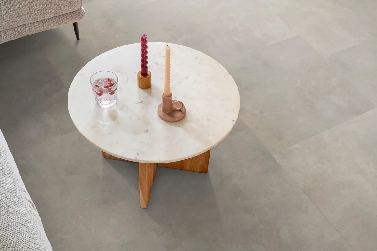 Victoria / Ceramo beige, plak pvc in een woonkamer, met een ronde marmeren salontafel en twee kaarsen