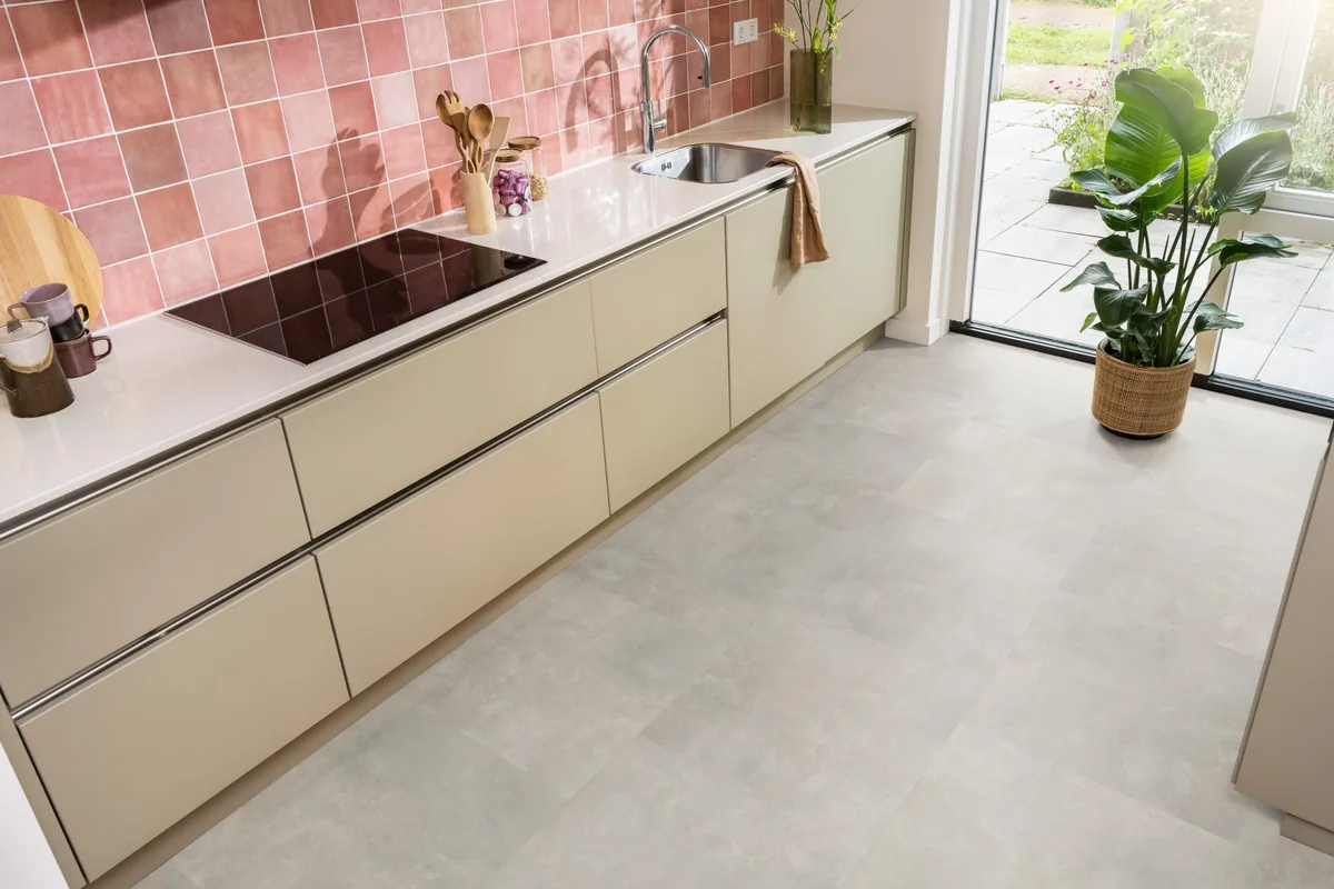Victoria / Ceramo beige, plak pvc in een keuken met een roze tegelwand en openslaande tuindeuren