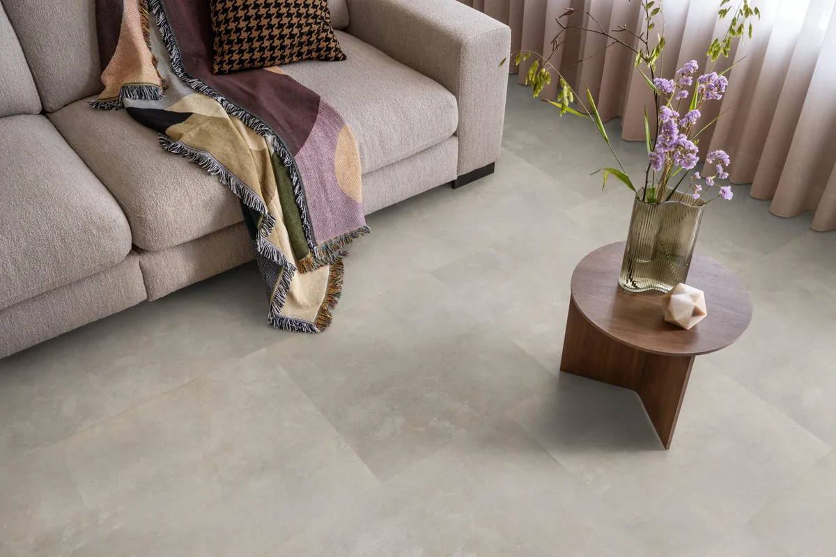 Victoria / Ceramo beige, plak pvc in een woonkamer, met een beige bank en een ronde bijzettafel met bloemen