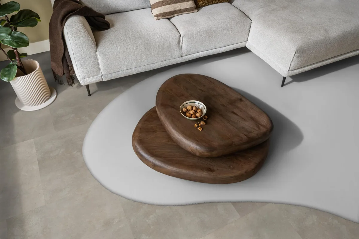 Victoria / Ceramo beige, plak pvc in een woonkamer, met een lichte hoekbank en een wit vloerkleed