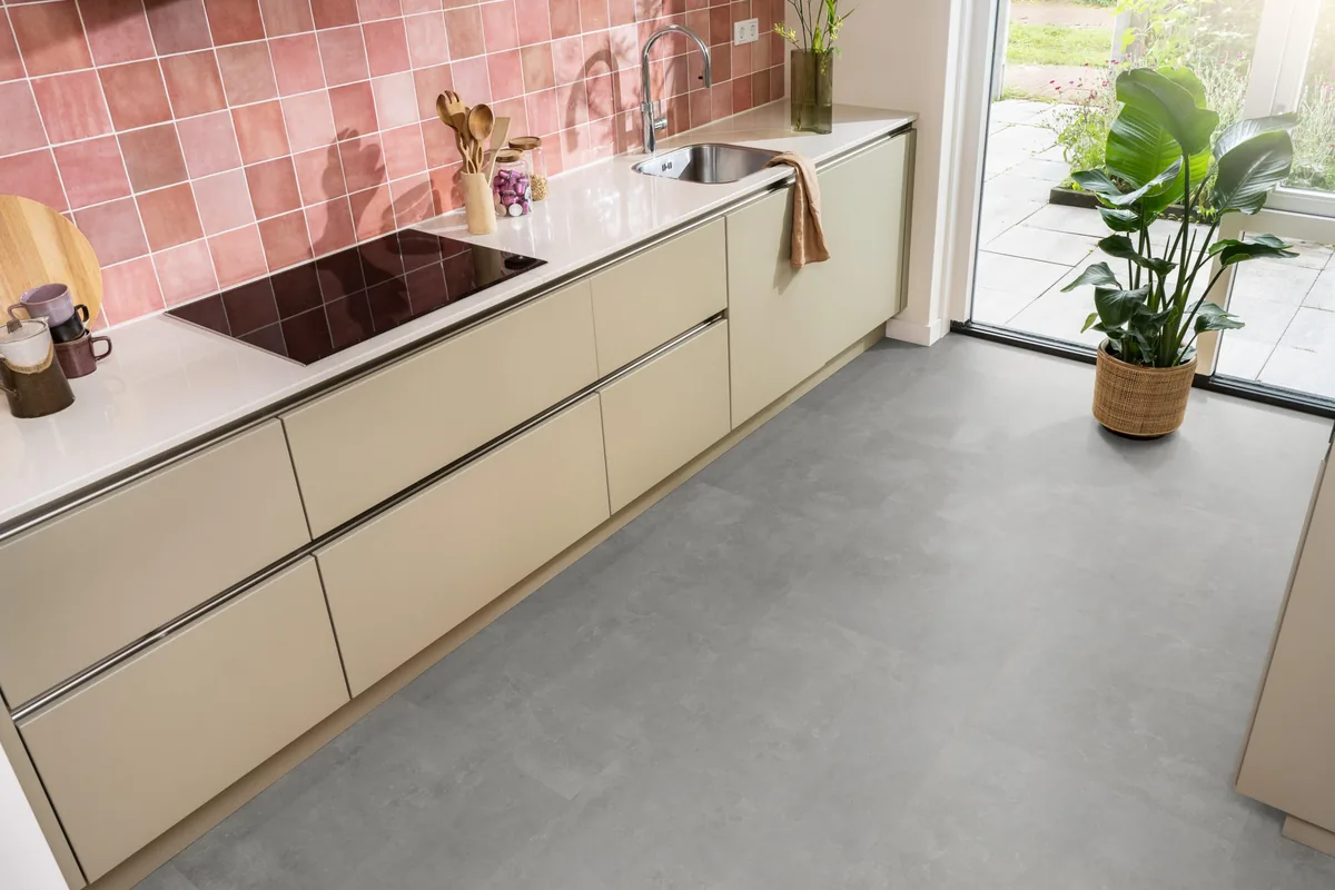 Victoria / Ceramo grey, plak pvc in een keuken met een roze tegelwand en openslaande tuindeuren