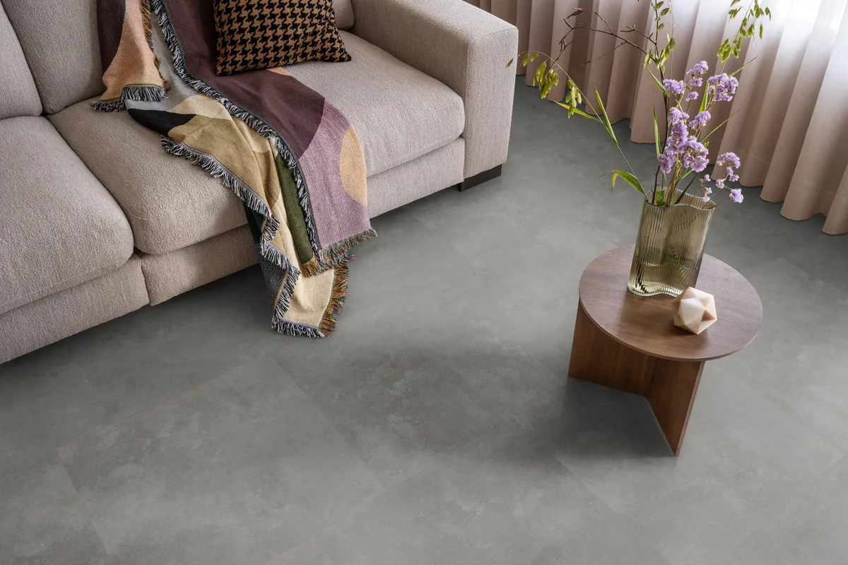 Victoria / Ceramo grey, plak pvc in een woonkamer, met een beige bank en een ronde bijzettafel met bloemen