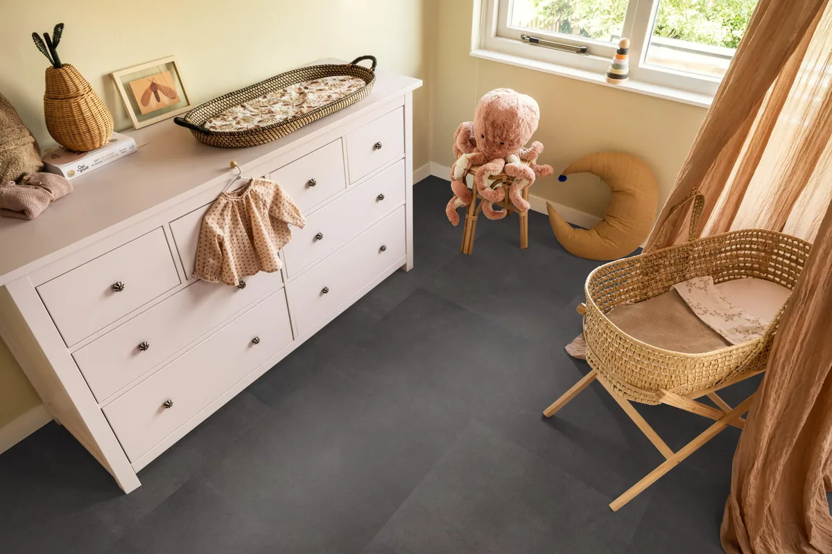 Peckham / Baroso anthracite, plak pvc in een babykamer, met een witte commode en een rieten wieg