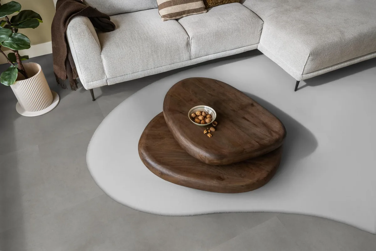 Peckham / Baroso grey, klik pvc in een woonkamer, met een lichte hoekbank en een wit vloerkleed