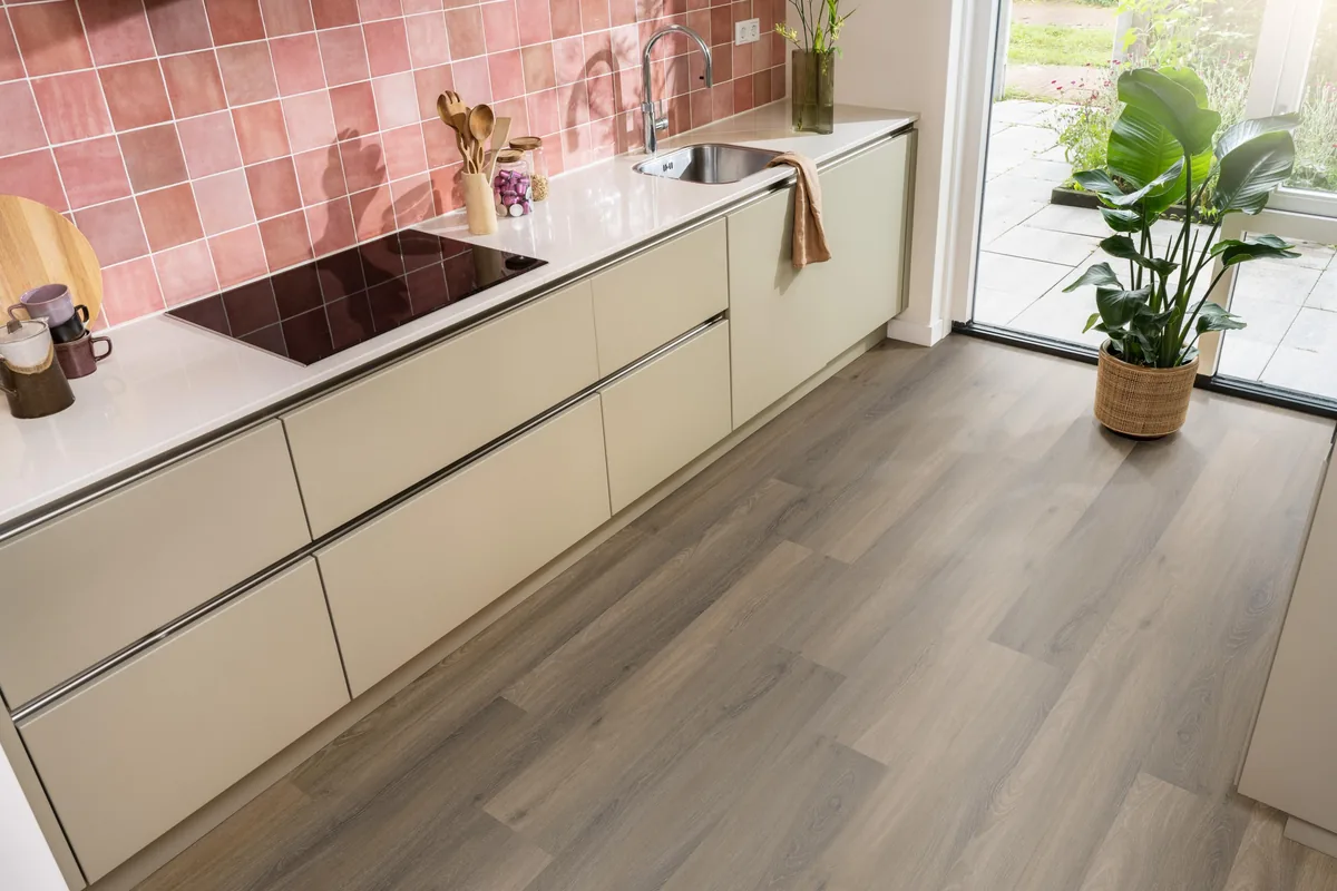 Paddington / Avanto Warm brown, klik pvc in een keuken met een roze tegelwand en openslaande tuindeuren