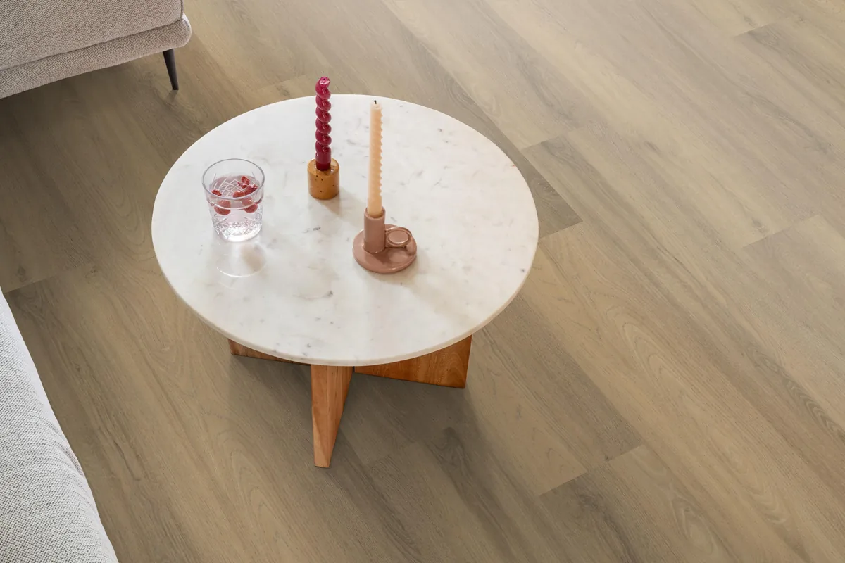Paddington / Avanto natural, klik pvc in een woonkamer, met een ronde marmeren salontafel en twee kaarsen