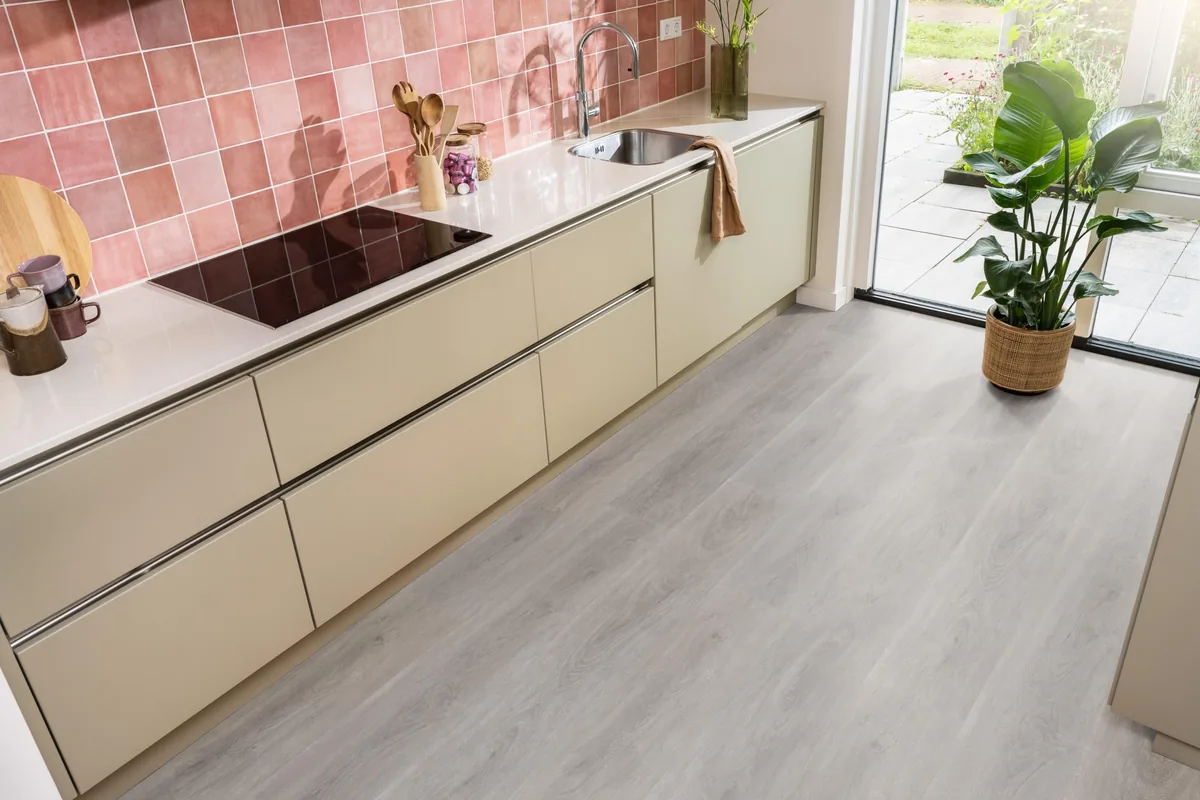 Parramatta / Robusto Grey oak, klik pvc in een keuken met een roze tegelwand en openslaande tuindeuren